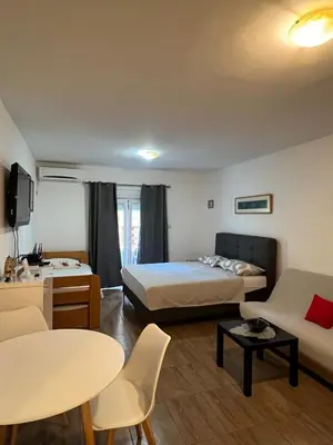 a hotel room with a bed and a couch at Quiet Studio Bečići Garage available 5 e per day in Boreti