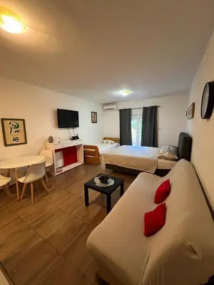 a hotel room with a bed and a couch at Quiet Studio Bečići Garage available 5 e per day in Boreti