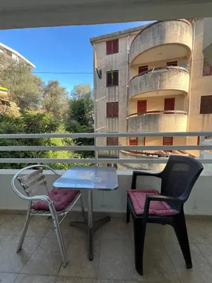 a table and chairs on a balcony with a building at Quiet Studio Bečići Garage available 5 e per day in Boreti