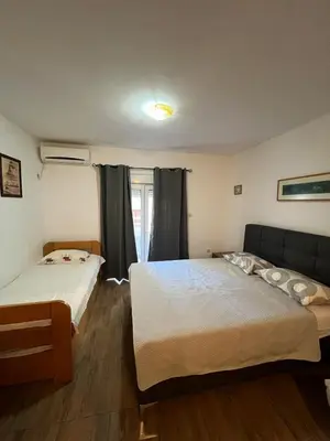 a bedroom with two beds and a couch at Quiet Studio Bečići Garage available 5 e per day in Boreti