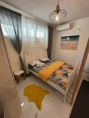 a small bedroom with a bed and a window at Stex Prime City Kvart in Podgorica