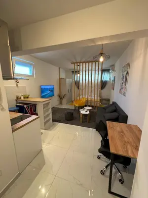a kitchen and living room with a table and chairs at Stex Prime City Kvart in Podgorica