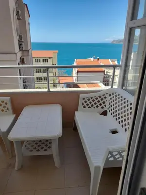 a balcony with a bench and a view of the ocean at Apart SASHENKA in Bar