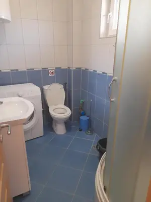 a blue and white bathroom with a toilet and sink at Apart SASHENKA in Bar