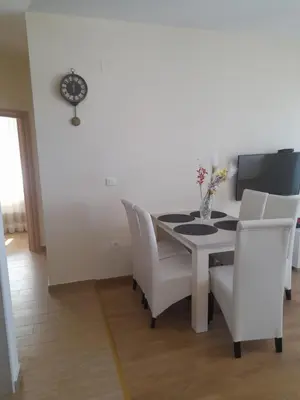 a dining room with a white table and white chairs at Apart SASHENKA in Bar