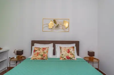 a bedroom with a green bed with two pillows at Apartments Fortunella in Petrovac na Moru