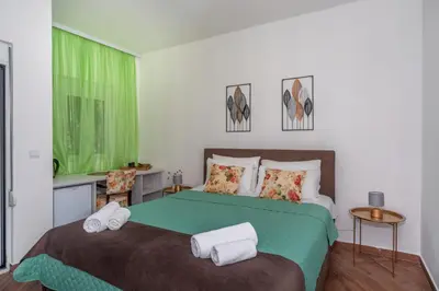 a bedroom with a large bed with towels on it at Apartments Fortunella in Petrovac na Moru