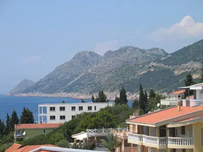a view of houses and the ocean and mountains at Guest House Dena in Dobra Voda