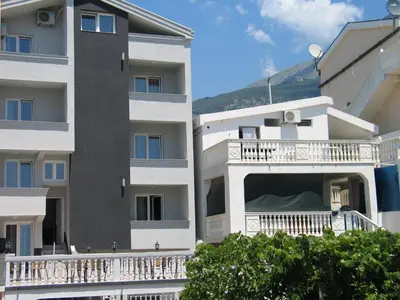 a white apartment building with a balcony at Guest House Dena in Dobra Voda