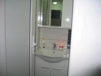 a bathroom with a sink and a mirror at Guest House Dena in Dobra Voda