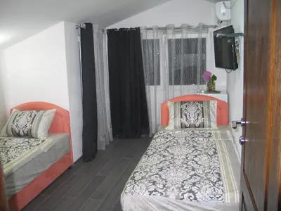 a bedroom with two beds and a tv in it at Guest House Dena in Dobra Voda