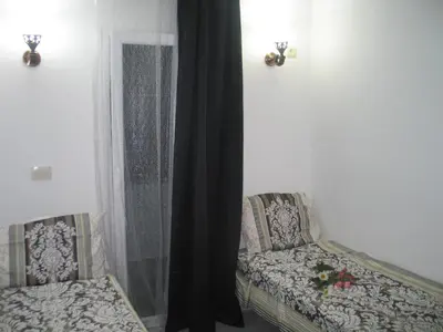a room with two chairs and a window with a curtain at Guest House Dena in Dobra Voda