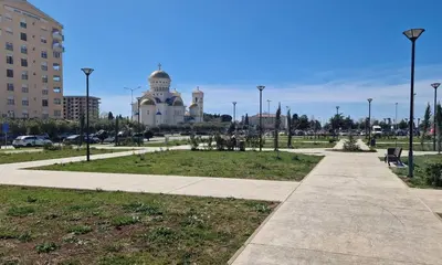 a walkway in a park with a building in the background at Apartment ENJOY in Bar