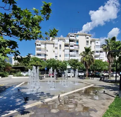 a fountain in a park in front of a building at Apartment ENJOY in Bar