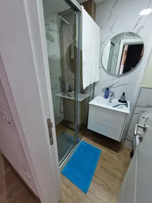 a bathroom with a shower and a blue rug at Apartment ENJOY in Bar