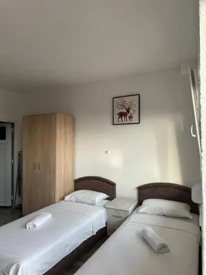 two beds in a hotel room with two beds sidx sidx sidx at Benelux Šušanj in Bar