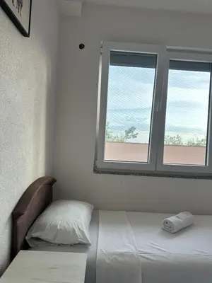 a bedroom with a bed and a window at Benelux Šušanj in Bar