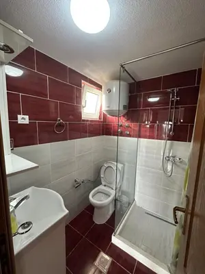 a bathroom with a toilet and a glass shower at Benelux Šušanj in Bar