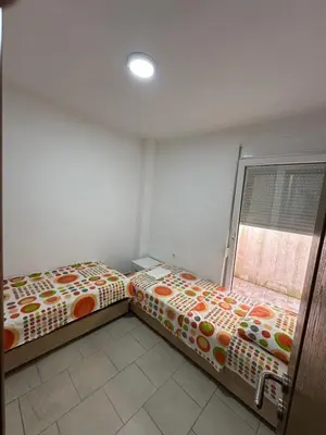 two beds sitting next to each other in a room at Benelux Šušanj in Bar