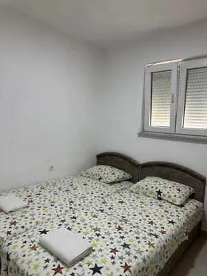 a bed with a comforter with a laptop on it at Benelux Šušanj in Bar