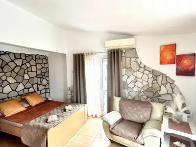 a bedroom with a bed and a couch at Villa Radis in Dobra Voda