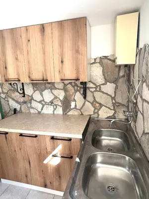 a kitchen with a sink and a stone wall at Villa Radis in Dobra Voda