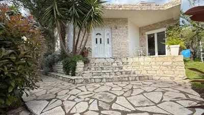 a house with a stone walkway in front of a house at Guest House Victoria in Bar