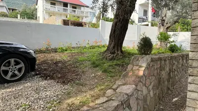 a car parked next to a stone retaining wall at Guest House Victoria in Bar
