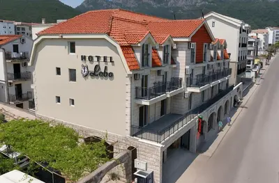 a building with a hotel on the side of a road at Hotel Lobo Budva in Budva