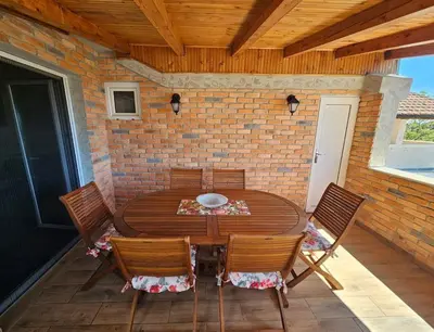 a wooden table and chairs on a patio at Apartment Lamer in Petrovac na Moru