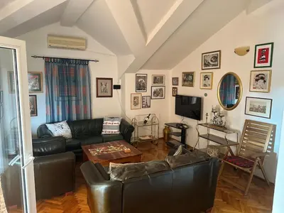 a living room with a leather couch and a tv at Apartment Lamer in Petrovac na Moru