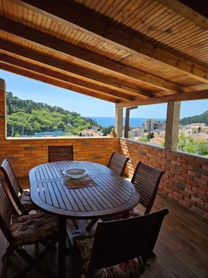 a wooden table and chairs on a patio at Apartment Lamer in Petrovac na Moru