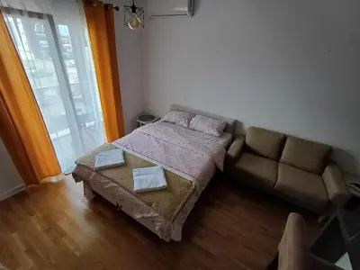 a small bedroom with a bed and a couch at Ventura lux in Podgorica