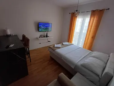 a bedroom with a bed and a desk and a television at Ventura lux in Podgorica