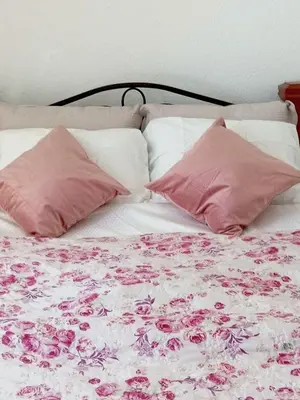 a bed with pink pillows and pink roses on it at AdelFa 2025- Welcome to Rest in Bar