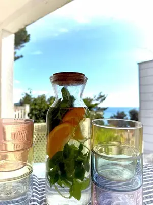 a bottle of water and two glasses on a table at AdelFa 2025- Welcome to Rest in Bar
