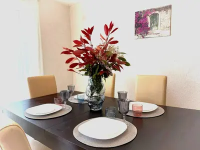 a table with plates and a vase of flowers on it at AdelFa 2025- Welcome to Rest in Bar