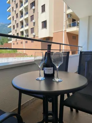 a table with a bottle of wine and two glasses at Blue Horizon Apartment in Becici in Budva