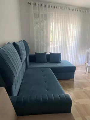 a living room with a blue couch and a table at Blue Horizon Apartment in Becici in Budva