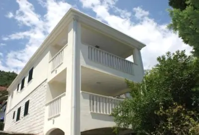 a white building with balconies on the side of it at Villa Lara Budva in Budva