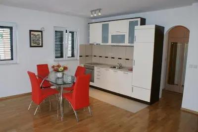 a kitchen with a dining table and red chairs at Villa Lara Budva in Budva