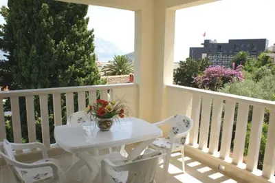 a white table and chairs on a white balcony at Villa Lara Budva in Budva