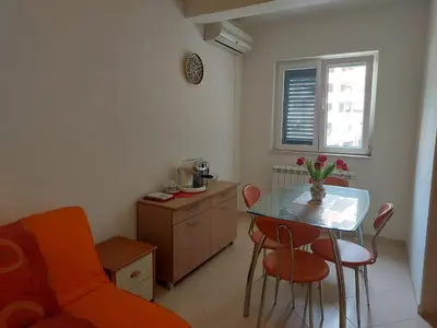 a living room with a table and a chair at Villa Lara Budva in Budva