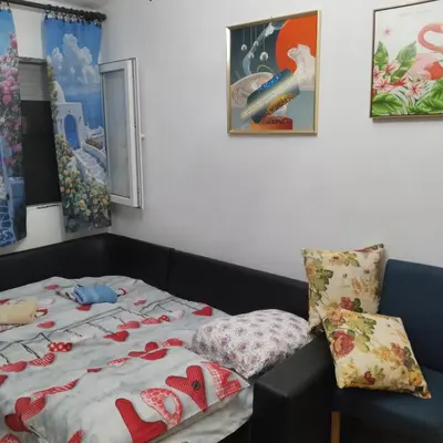 a bedroom with a bed and some pictures on the wall at Apartman ElaBi in Bar