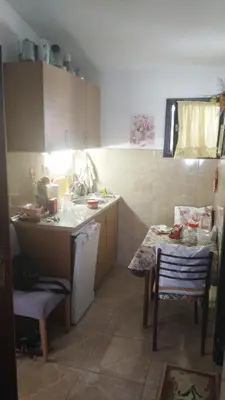 a small kitchen with a table and a sink at Apartman ElaBi in Bar