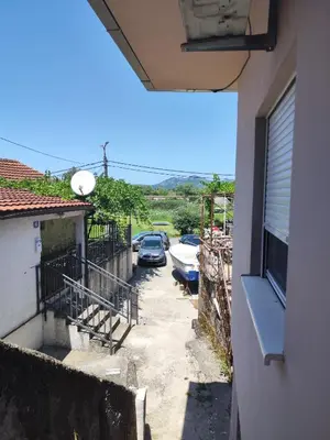 an alley between two buildings with cars parked at Apartments Skadar Lake in Vranjina