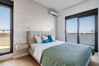 a bedroom with a large bed with blue pillows at Twin Towers By In Property in Becici