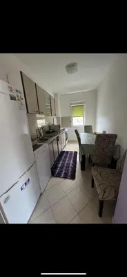 a kitchen with a refrigerator and a table and chairs at Stan na dan Bar in Bar, Susanj