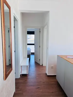 a room with a hallway with a mirror and a table at Swiss DELUXE Appartement in Dobra Voda