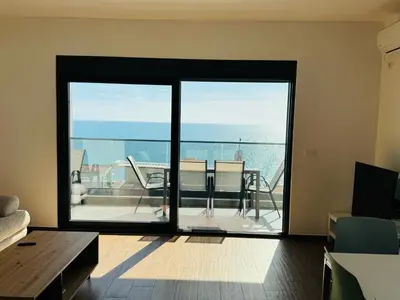 a living room with a large sliding glass door at Swiss DELUXE Appartement in Dobra Voda